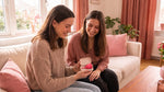 Duas amigas com o estojo GIOCUP® aberto e o copo menstrual Rose lá dentro