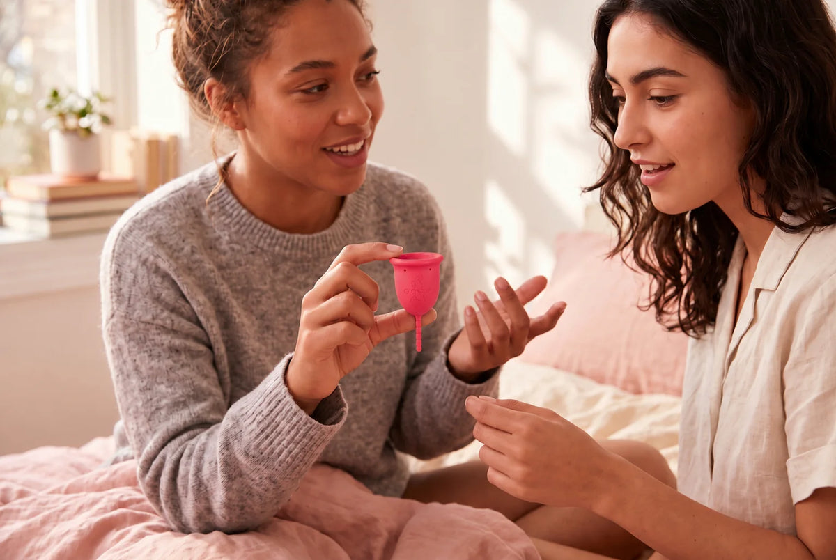 Two friends: one shows the other the GIOCUP® menstrual cup