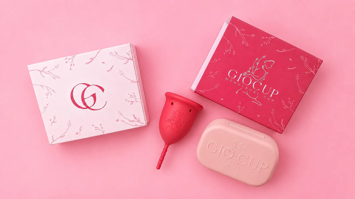 White and pink GIOCUP® boxes, a Rose menstrual cup and the GIOCUP® case on a pink background