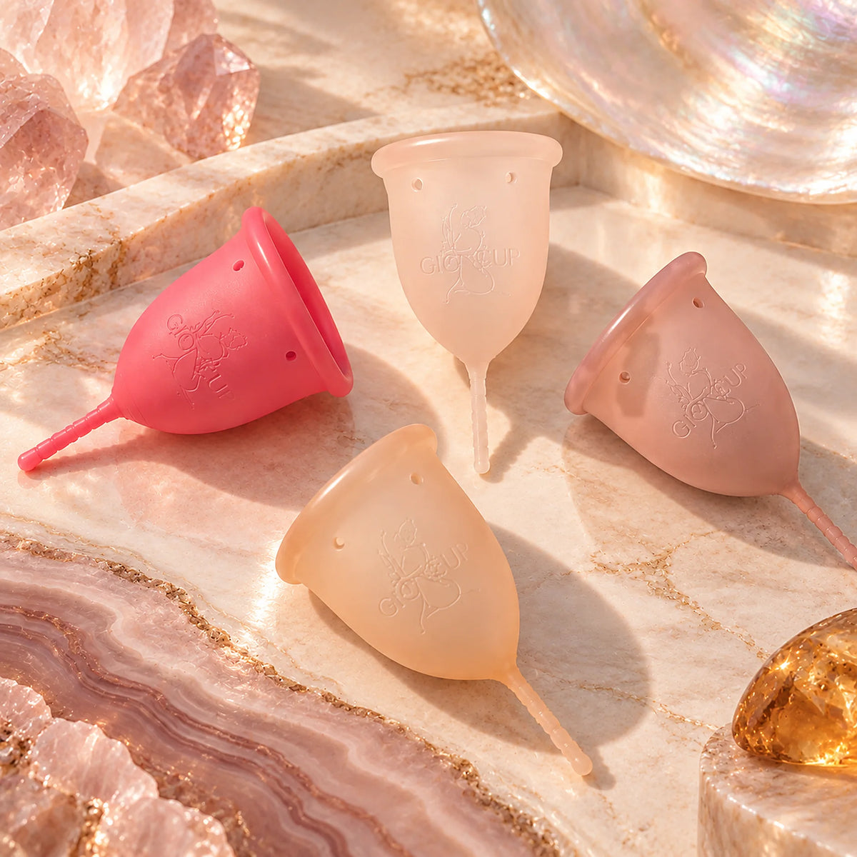 Os quatro copos menstruais GIOCUP® entre cristais de ágata