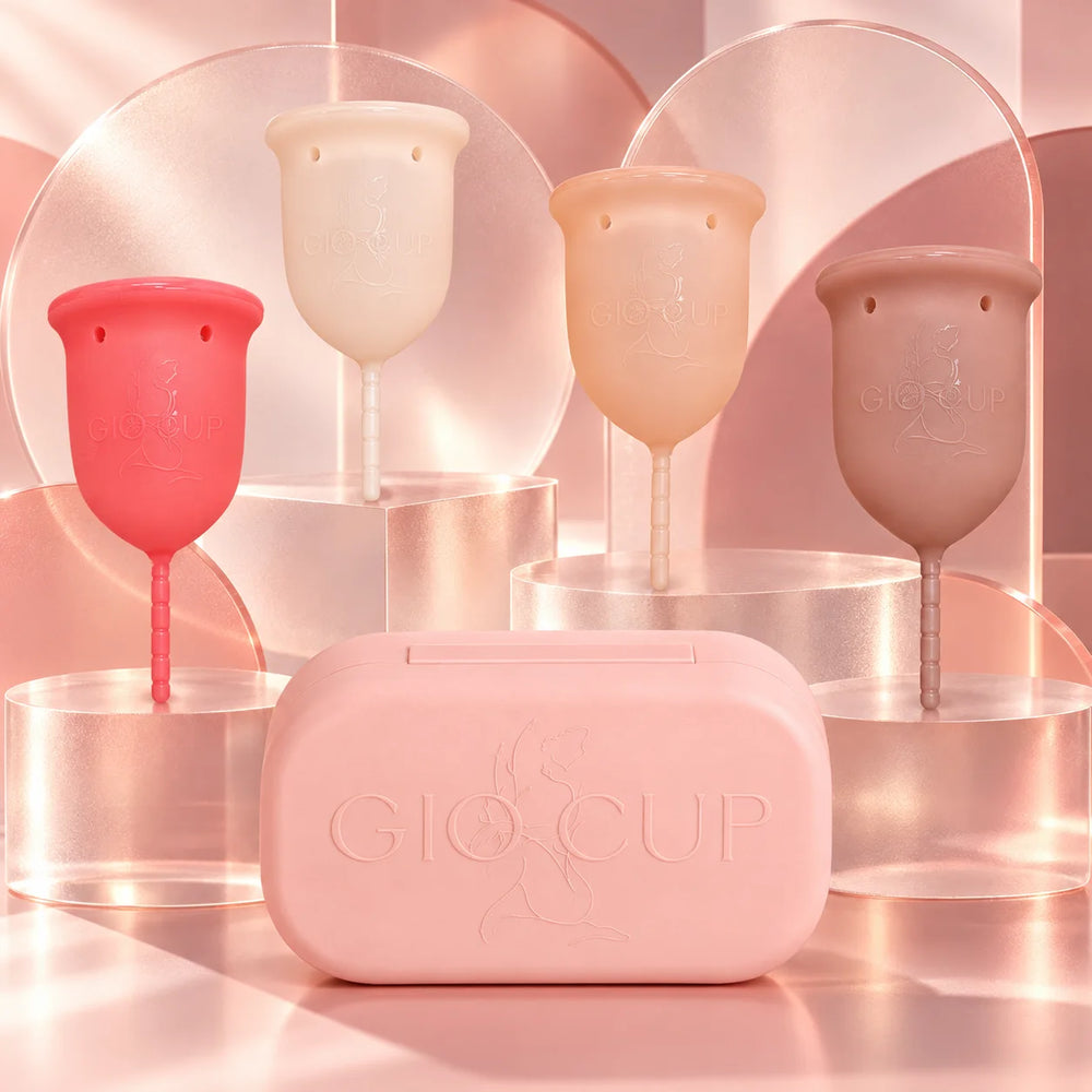 Os quatro copos menstruais GIOCUP® de pé, com o estojo do copo menstrual à frente