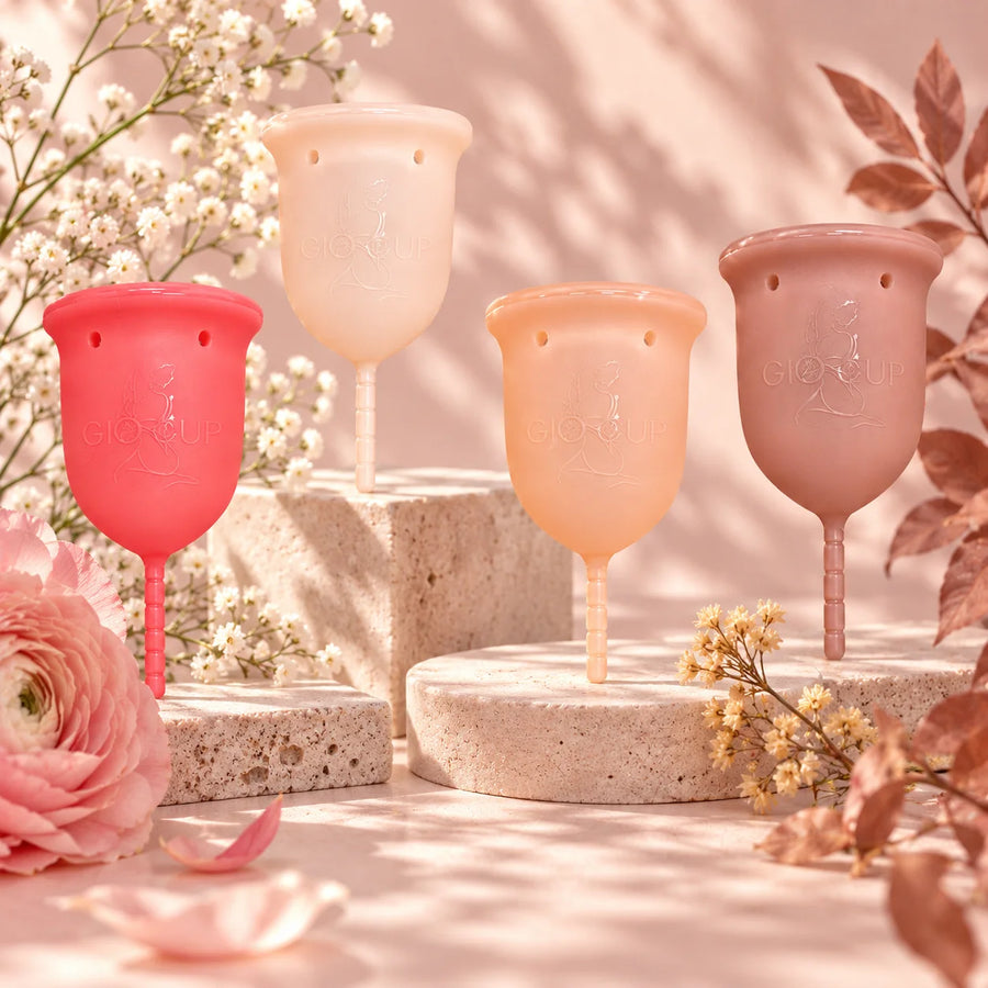 GIOCUP® Rose, Pearl, Amber and Agate menstrual cups standing among stones and flowers