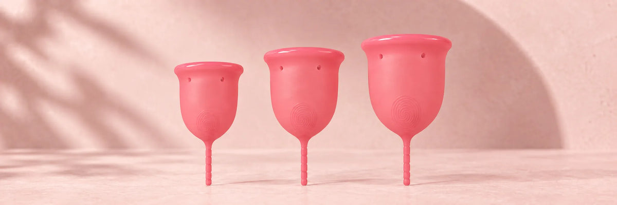 Os três tamanhos do copo menstrual GIOCUP® Rose, lado a lado, do mais pequeno ao maior